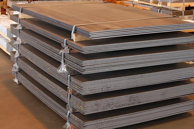 Chapas de aço carbono empilhadas em fábrica.